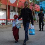 Dua orang tua menggandeng anaknya menuju ruang kelas pada hari pertama tahun ajaran baru di SD Negeri Sudirman, Makassar, Sulawesi Selatan, Senin (13/7/2026). (ANTARA FOTO/HASRUL SAID)
