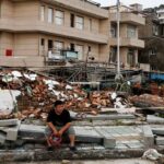 Foto: Seseorang duduk di samping tembok yang runtuh pasca Topan Bavi di desa pesisir Dongsha, Taizhou, provinsi Zhejiang, China, 12 Juli 2026. (REUTERS/Go Nakamura)